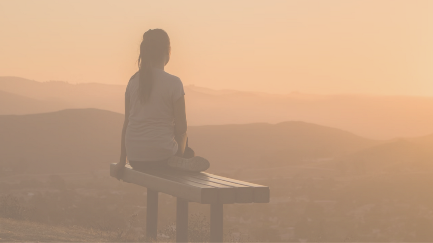 Vrouw kijkend naar bergen tijdens een zonsondergang