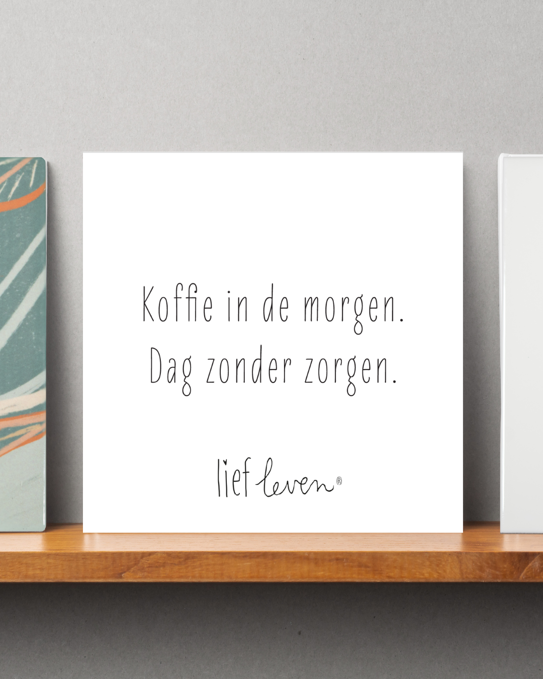 Tegeltje van Lief Leven met de tekst ‘Koffie in de morgen. Dag zonder zorgen.’ in zachte, minimalistische stijl op glanzend keramiek.