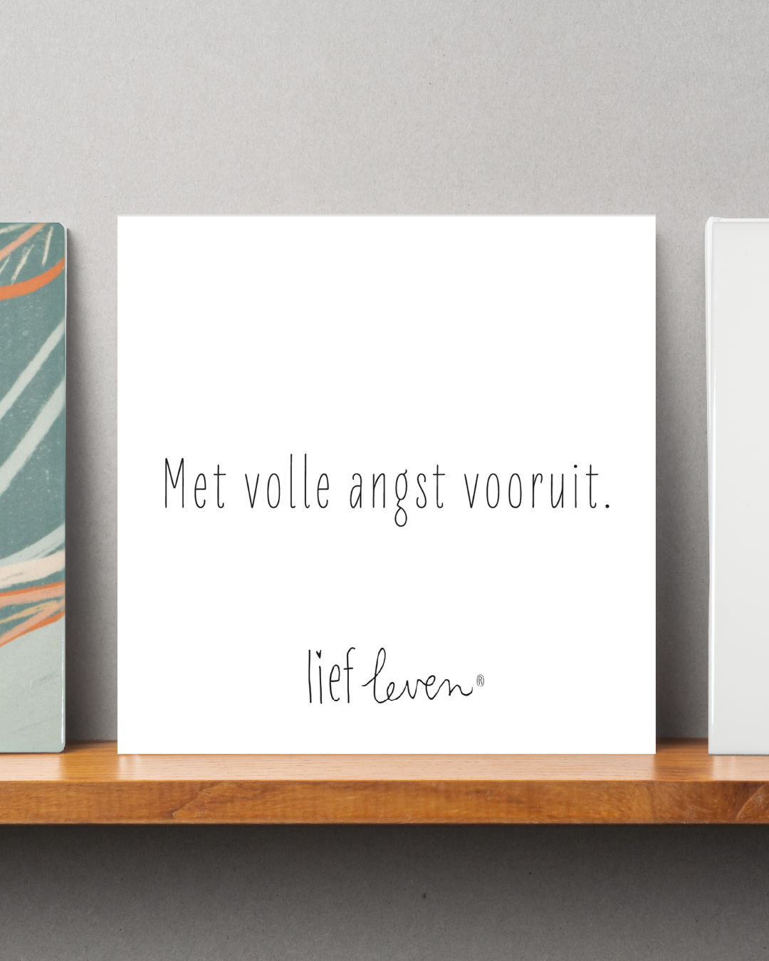 Tegeltje van Lief Leven met de tekst ‘Met volle angst vooruit.’ in zachte, minimalistische stijl op glanzend keramiek.